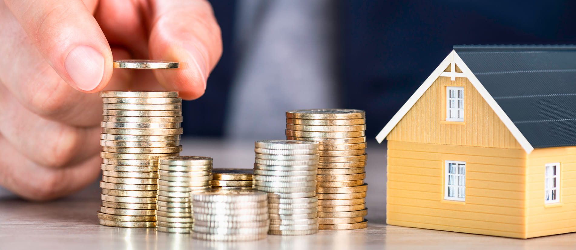 Man stacking coins on a table alluding to short term funding & bridging loans
